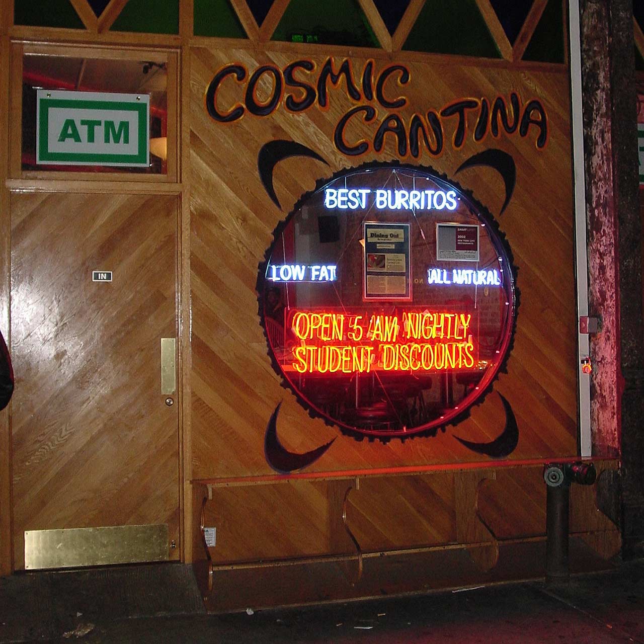 Cosmic Cantina sign pained on wood, with a round window.
