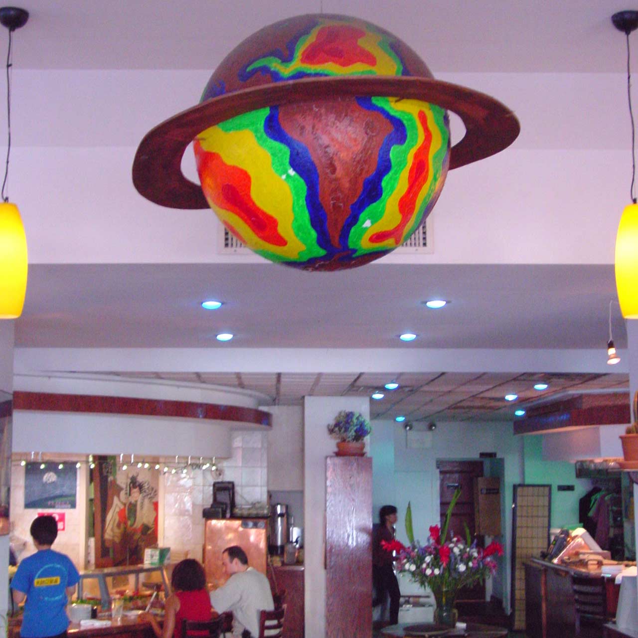 Inside Planet Sushi, with an artistic, ringed, multihued planet hanging from the ceiling.