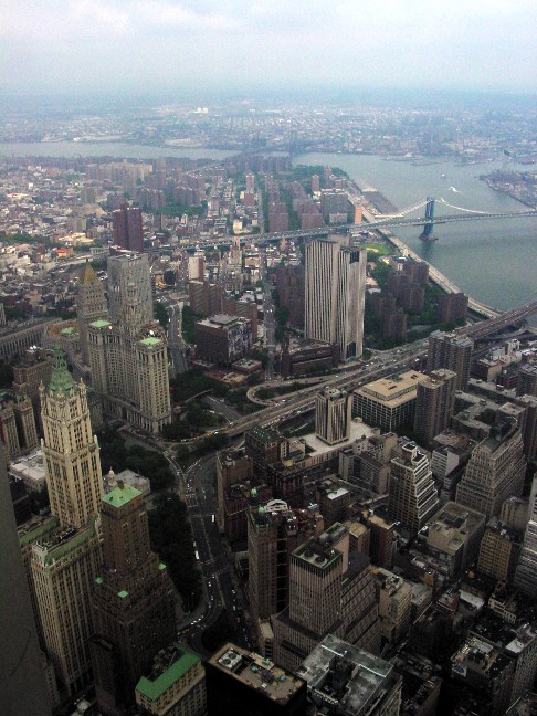 The view from 107th floor of World Trade Center, Tower 2, looking east. Pictured are the nearby buildings and skyscrapers, the East River, and the Manhattan Bridge.