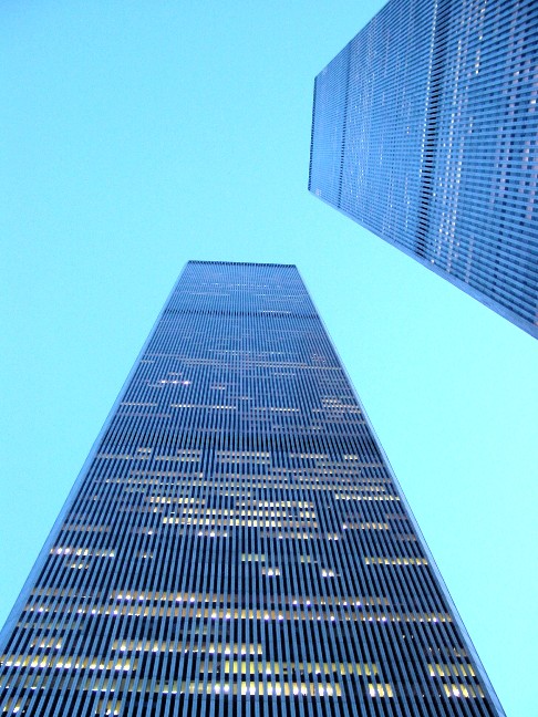The twin towers looking straight up. One tower rises from the bottom of the frame, and the other from the top-right of the frame. They converge toward a point in the top-center.