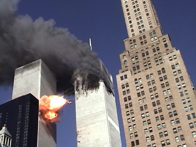 With Tower 1 on fire, Tower 2 is hit by the plane, showing a burst of flame.