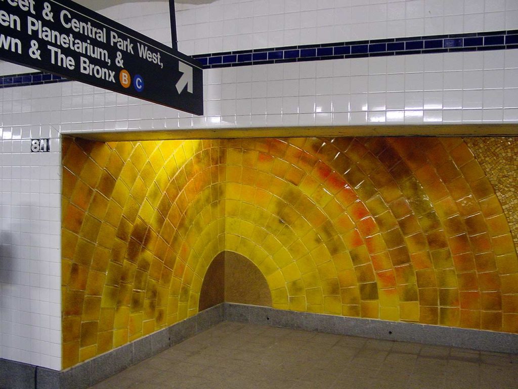 The base of a stairwell in the subwaystation with yellow tiled representing a cut-away of the Sun's interior.'