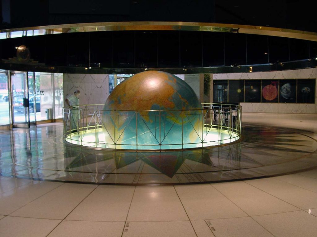 Photo inside the lobby, with the central globe and surrounding demarkations and posters in the background.