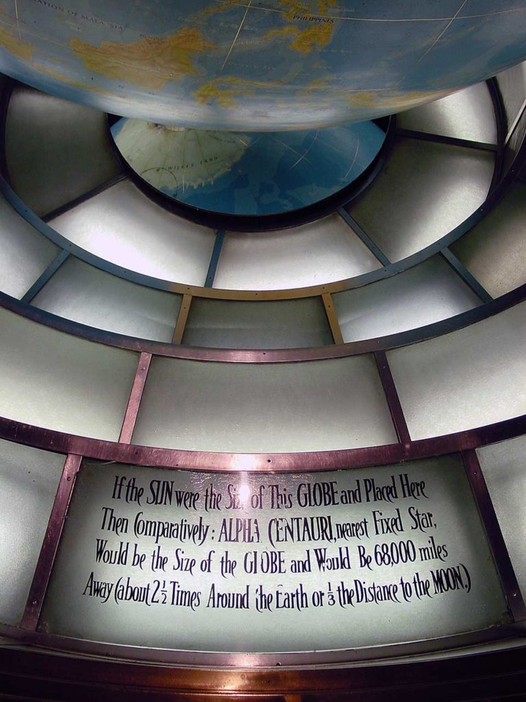 Close up of a sign beside the globe.