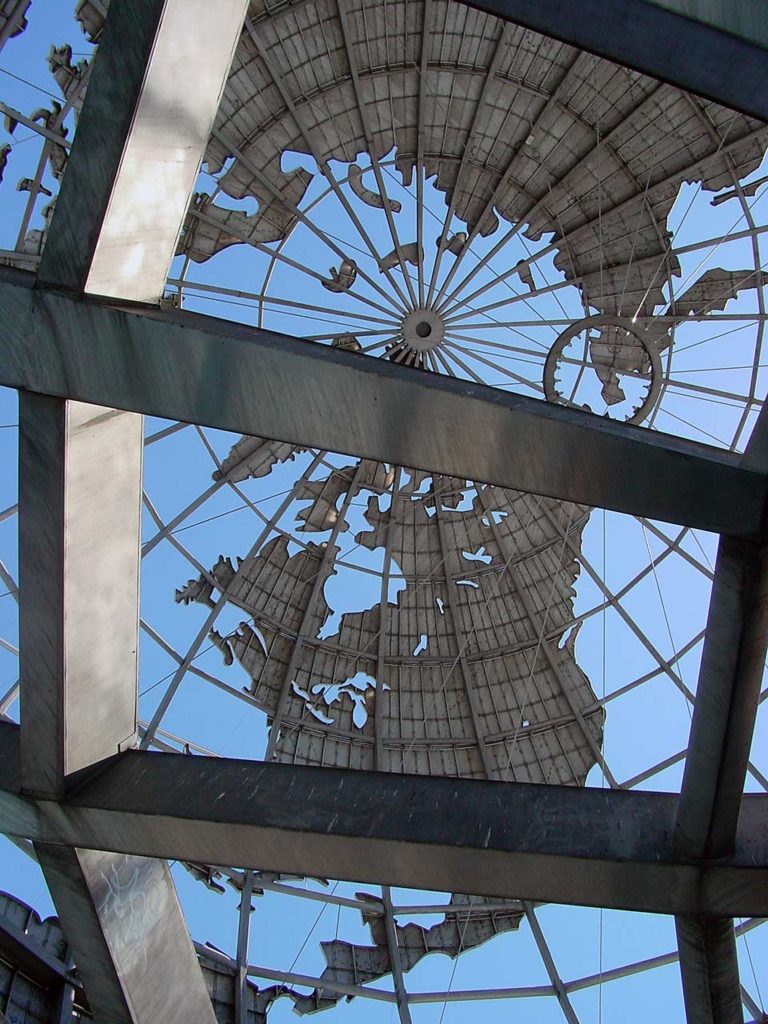 A photo from under the Unisphere, looking up into it, with the gridlines of latitude and longitide in the foreground, and the underside of the north polar region in the background.