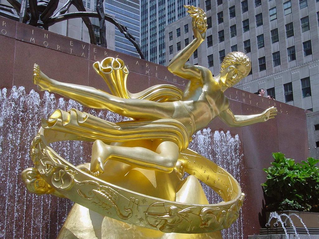 The golden Prometheus sculture in repose with a ribbon of symbols and creatures from the zodiacal constellations below.