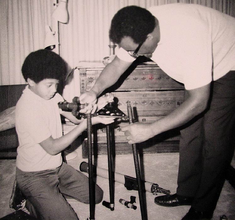 A photo of Neil’s father helping him set up a telescope.
